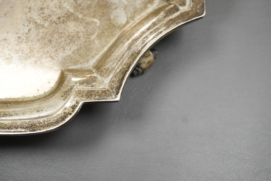 An early 20th century Indian white metal salver (tests as silver) by Hamilton & Co of Calcutta, of shaped square form, with inswept corners, on four scroll feet, 32.9cm, 38.7oz.